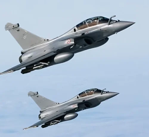 Deux avions de chasse militaires volent dans un ciel bleu clair en formation tandem, présentant des corps gris élégants et une aérodynamique pointue, transmettant vitesse et précision.